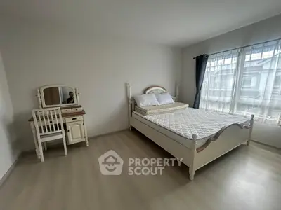 Spacious bedroom with elegant furniture and large window for natural light.