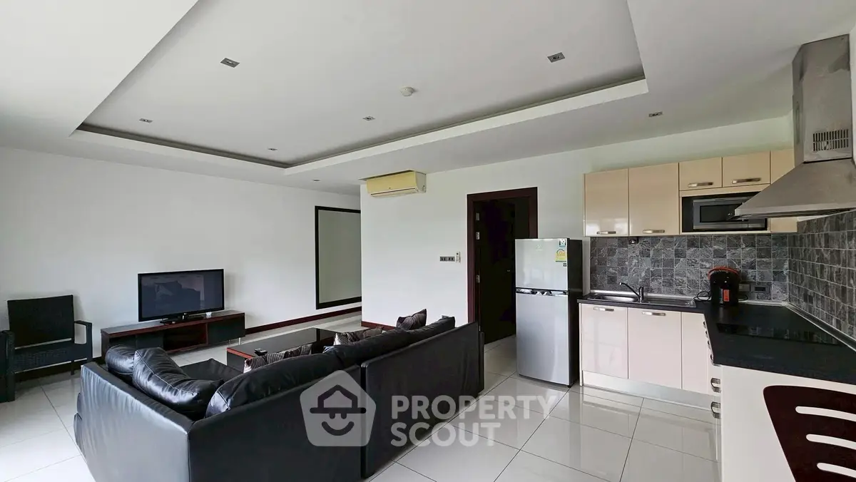 Modern open-layout living room with sleek kitchen and leather sofa