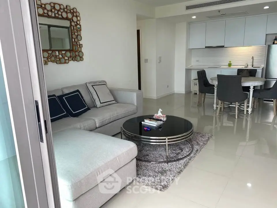 Modern living room with sleek kitchen, featuring stylish furniture and open layout.