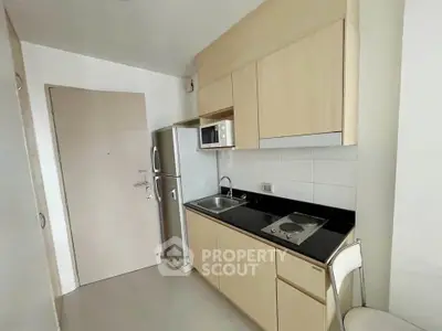 Modern compact kitchen with sleek cabinetry and stainless steel appliances.