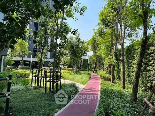 Lush garden pathway in modern residential complex with vibrant greenery and serene atmosphere.