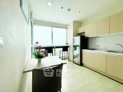 Bright modern kitchen with large window and dining area in stylish apartment.