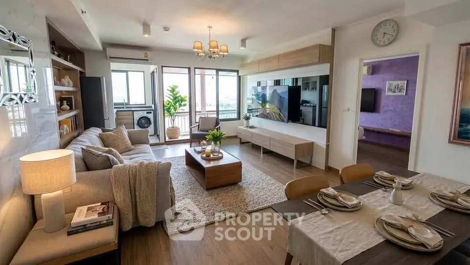 Spacious modern living room with elegant decor and open layout, featuring a cozy dining area and large windows.