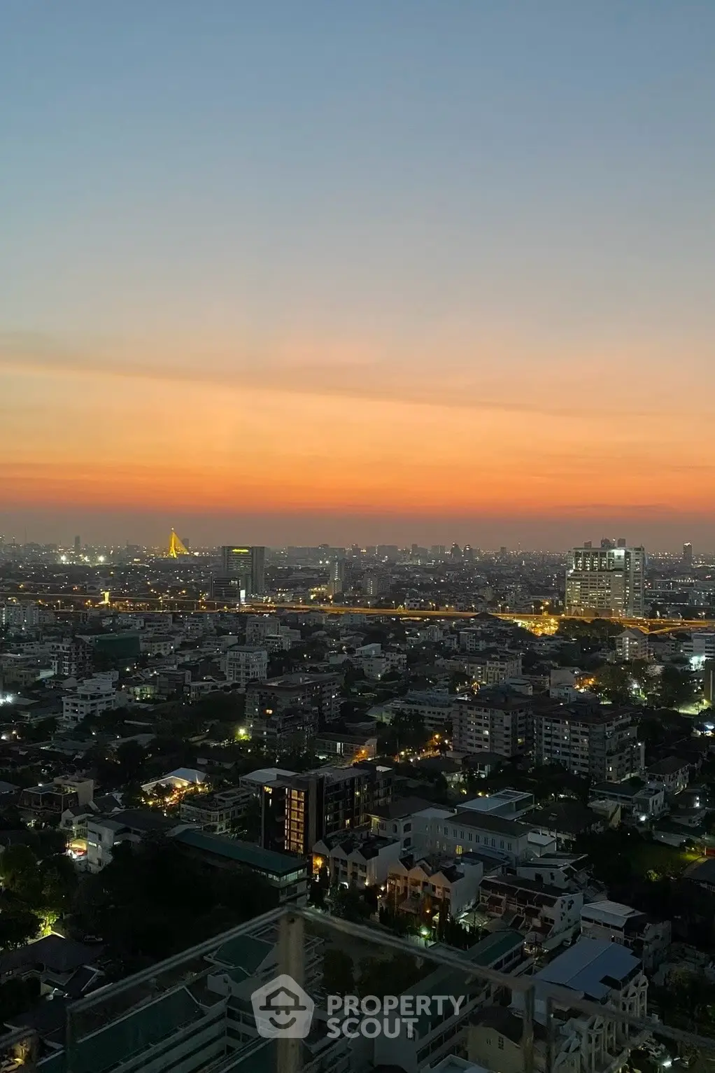 Stunning cityscape view at sunset from a high-rise building, showcasing urban skyline and vibrant sky.