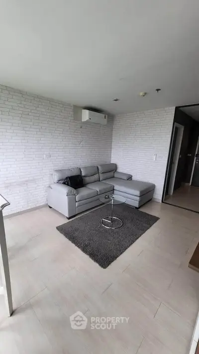 Modern living room with sleek gray sofa and stylish decor in a contemporary apartment.