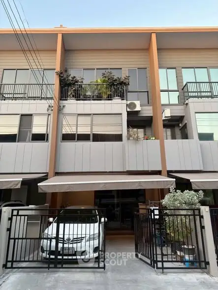 Modern townhouse exterior with gated parking and balcony
