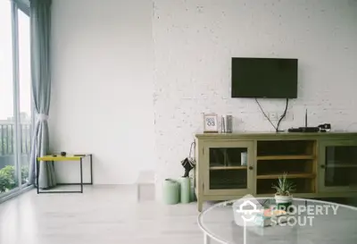 Modern living room with stylish decor and large windows offering natural light.