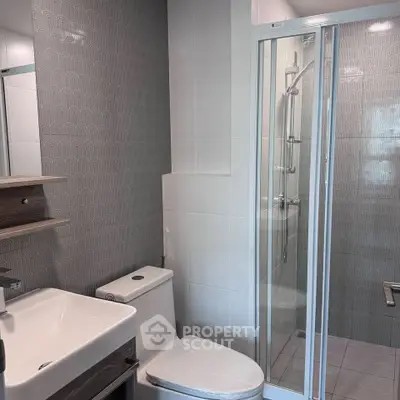 Modern bathroom with sleek shower and stylish sink in contemporary apartment.