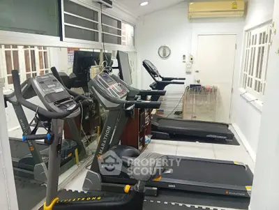 Modern gym with treadmills and exercise equipment in a bright, well-lit space.