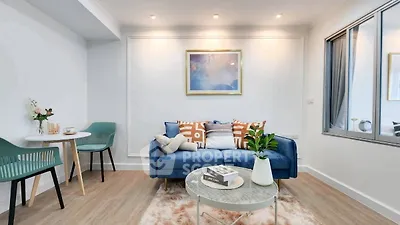 Stylish modern living room with blue sofa, chic decor, and cozy ambiance