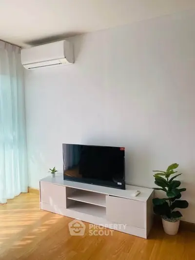 Modern living room with sleek TV stand and air conditioning, perfect for cozy relaxation.