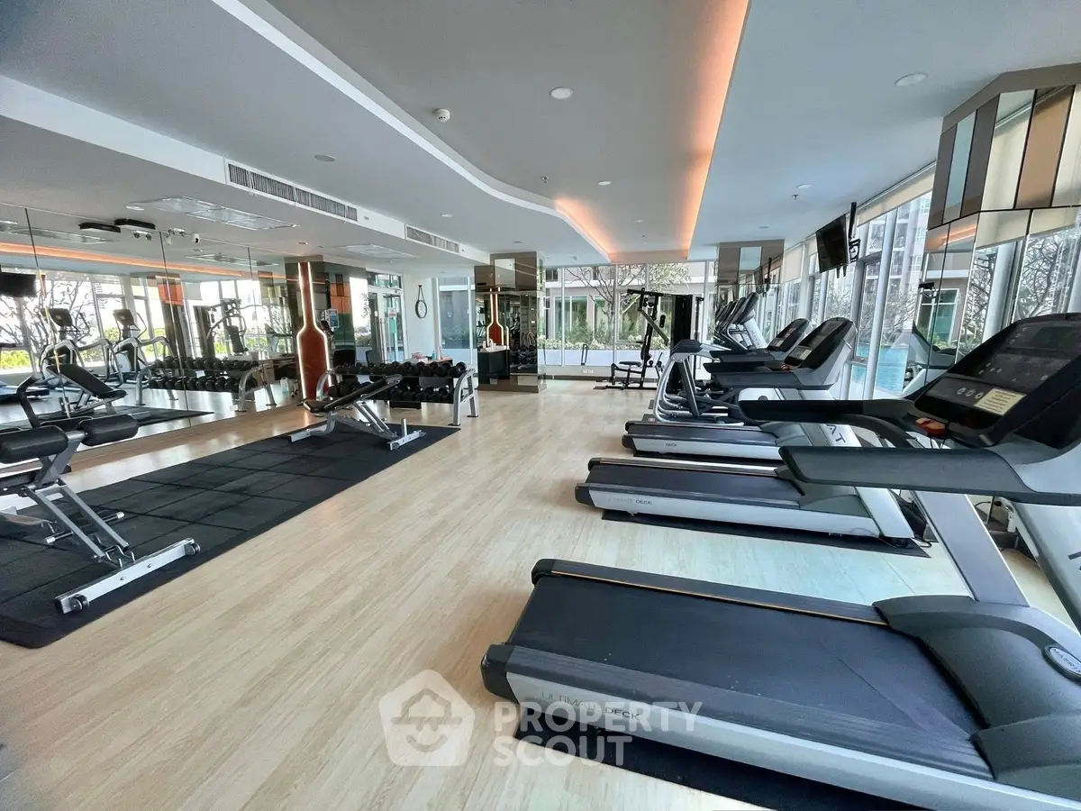 Modern gym with state-of-the-art equipment and mirrored walls in a luxury residential building.