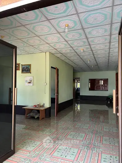 Spacious interior with unique patterned ceiling and tiled floor, ideal for creative renovation.