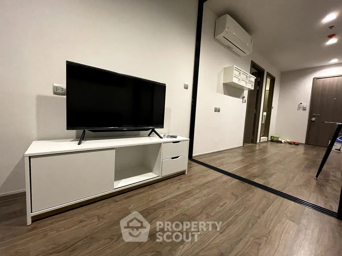 Modern living room with sleek TV stand and air conditioning in a stylish apartment.