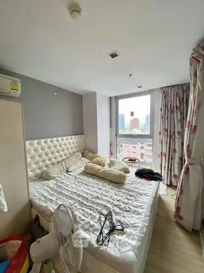 Cozy bedroom with city view, featuring a plush headboard and large window for natural light.
