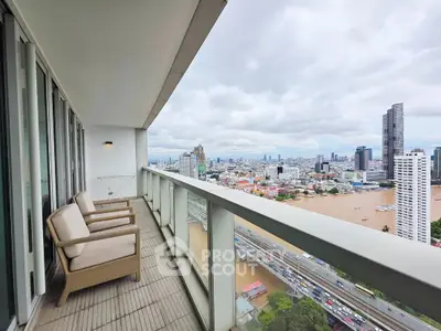 Spacious balcony with stunning city and river views from a high-rise apartment.