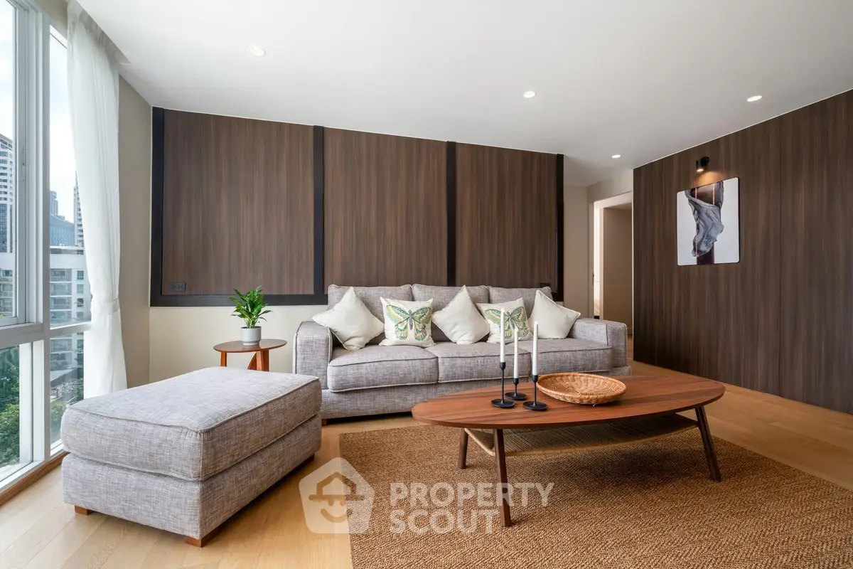 Spacious modern living room with stylish decor and large windows offering city views.