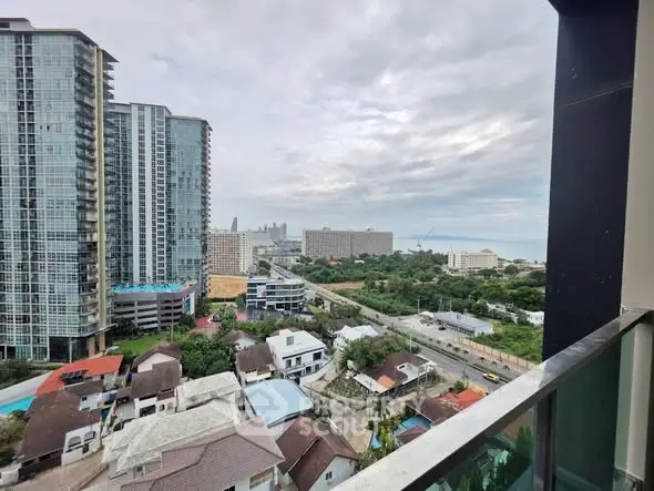 Stunning cityscape view from high-rise balcony overlooking urban skyline and lush greenery.