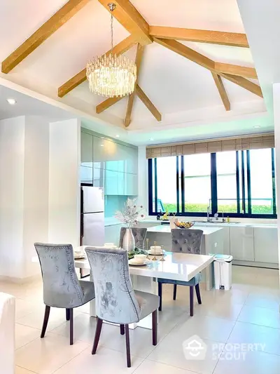 Elegant kitchen with dining area, high ceiling, and modern chandelier