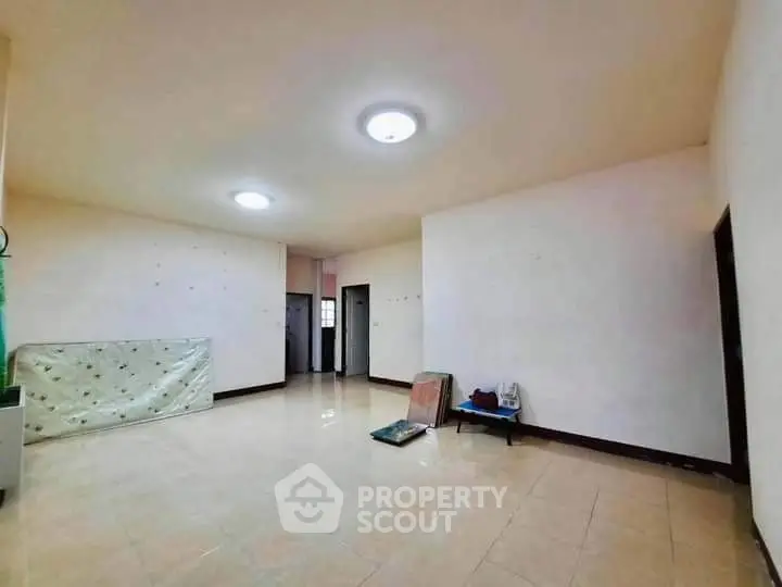 Spacious unfurnished room with tiled flooring and bright lighting, ideal for customization.