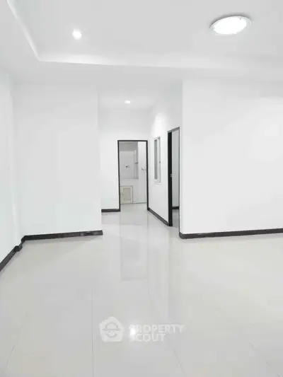 Spacious minimalist interior with glossy tiled floors and white walls