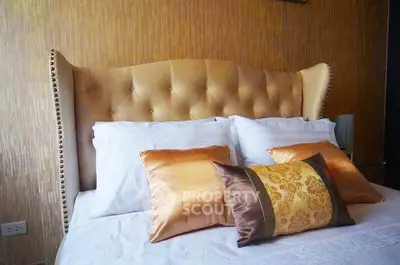 Luxurious bedroom with elegant headboard and plush pillows in a stylish interior setting.