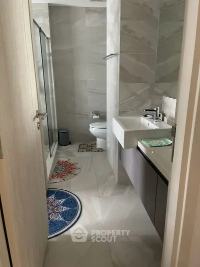 Modern bathroom with sleek design and elegant fixtures, featuring a spacious shower and stylish vanity.