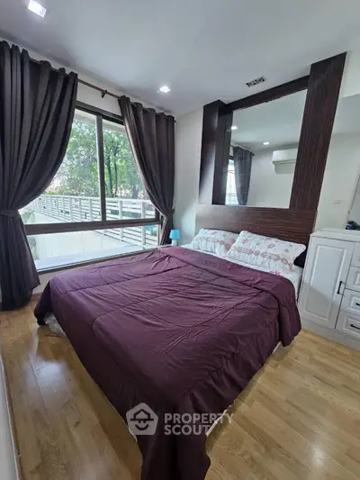 Cozy bedroom with large window and stylish decor in modern apartment