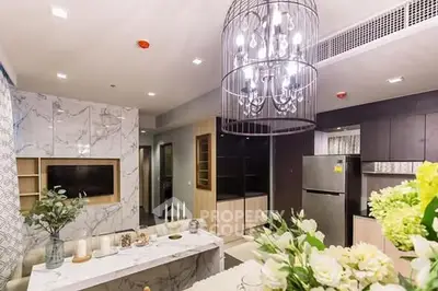 Luxurious modern living room with elegant chandelier and marble accents.