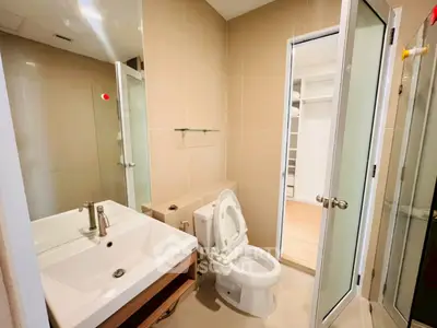 Modern bathroom with sleek fixtures and neutral tones, featuring a spacious layout and contemporary design.