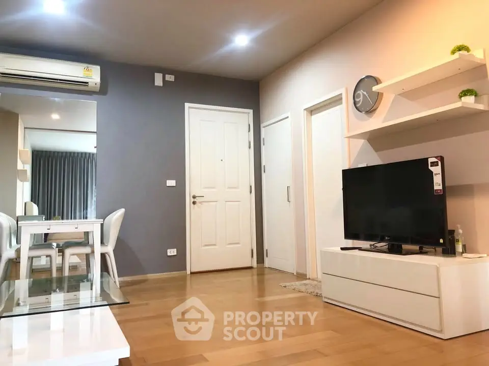 Modern living room with sleek furniture and wooden flooring in a stylish apartment.
