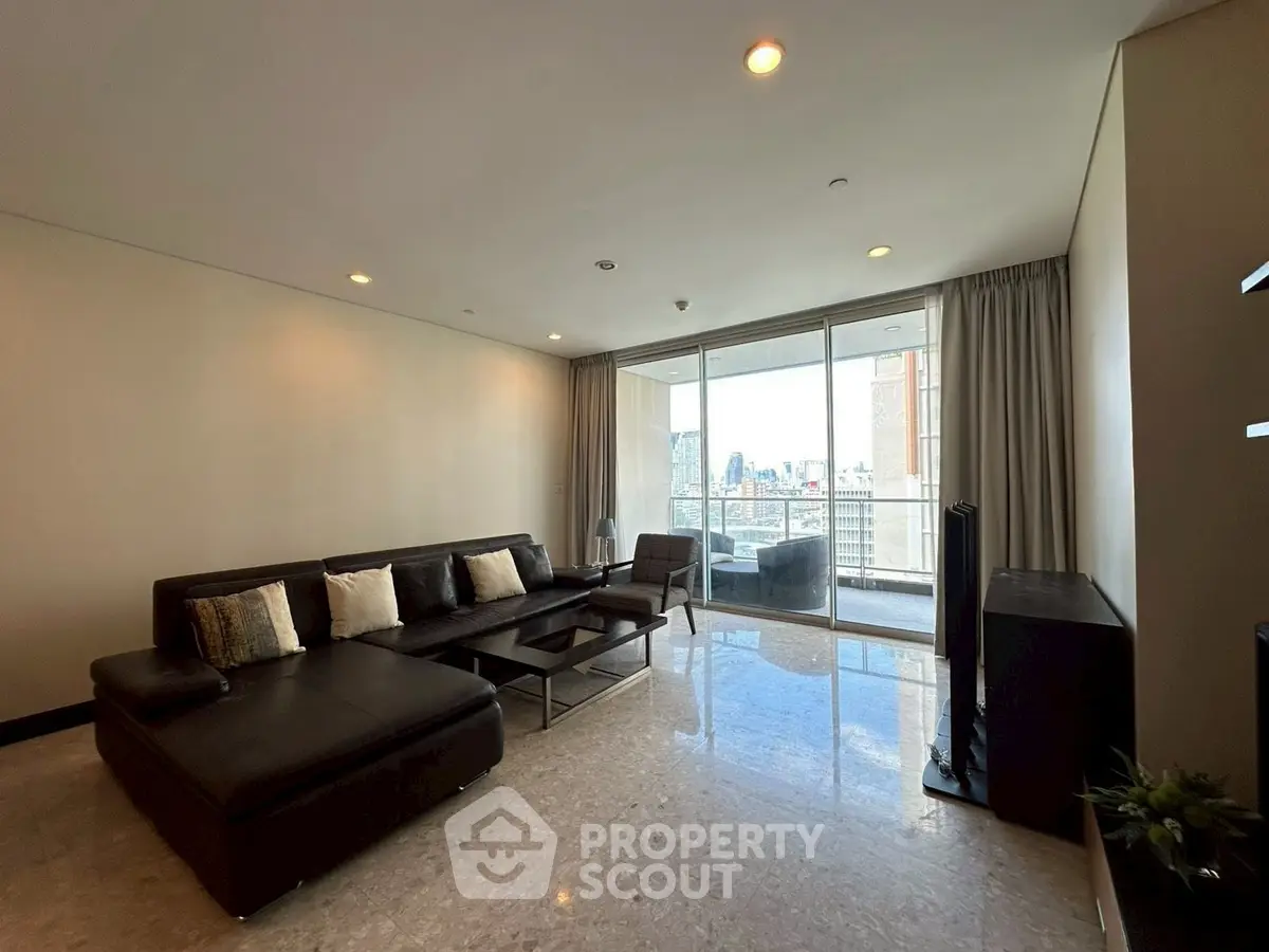 Spacious modern living room with sleek black sofa and city view balcony.