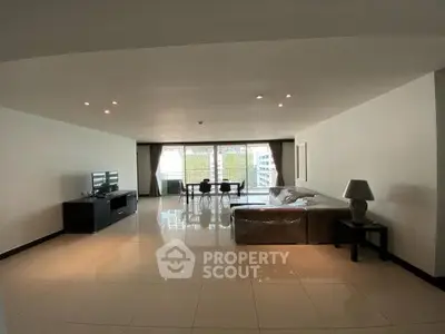 Spacious modern living room with sleek furniture and large windows offering natural light.