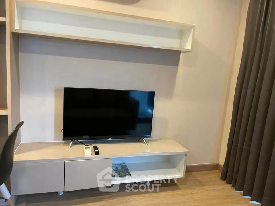 Modern living room with sleek TV stand and wall-mounted shelf, perfect for stylish urban living.