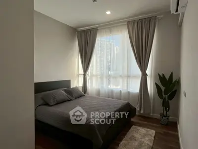 Cozy bedroom with large window and modern decor in urban apartment