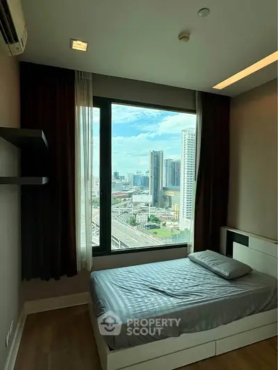 Cozy bedroom with stunning city view from large window in modern apartment.