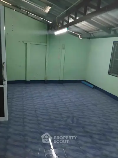 Spacious empty room with tiled floor and metal roof, ideal for customization.
