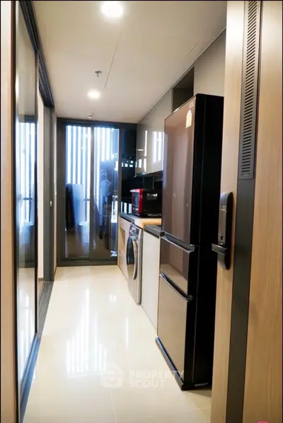Modern kitchen with sleek appliances and washing machine in compact layout