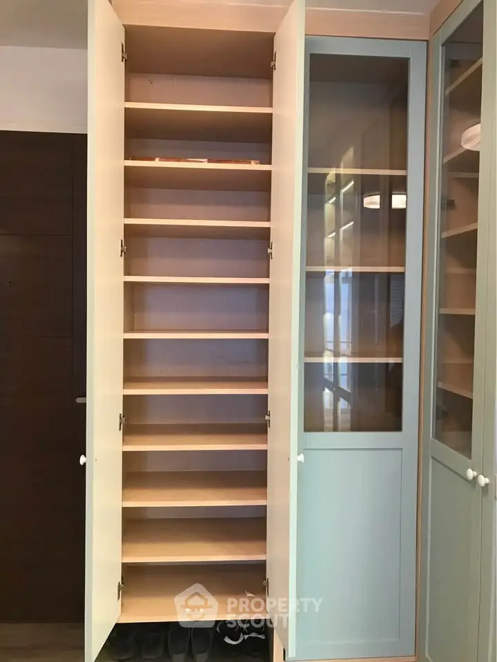 Spacious built-in storage cabinet with open shelves and glass doors, perfect for organizing home essentials.