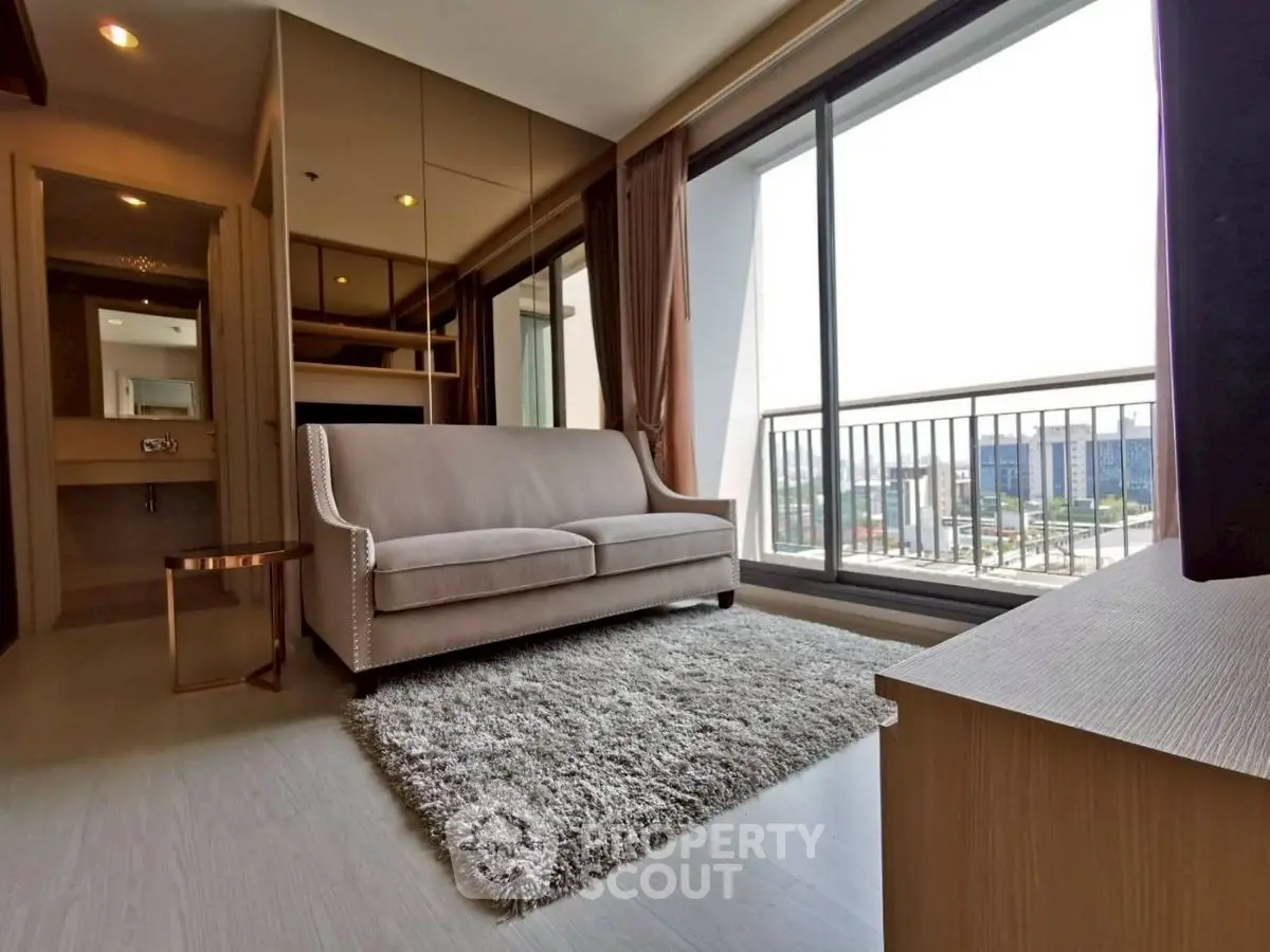Modern living room with large windows and cozy sofa in a high-rise apartment.