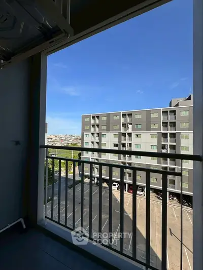 Modern apartment balcony with city view and clear blue sky