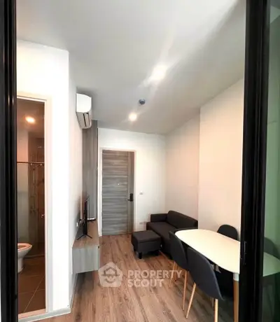 Modern living room with sleek furniture and wooden flooring in a cozy apartment.