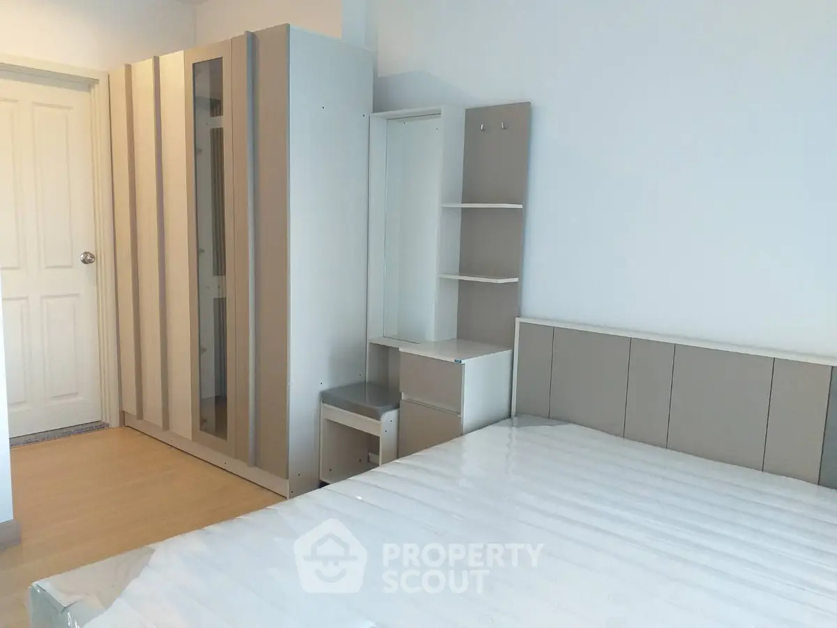 Modern bedroom with sleek furniture and ample storage space in a stylish apartment.