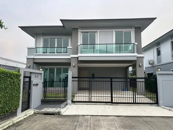 Modern two-story house with sleek design and spacious driveway in a suburban neighborhood.