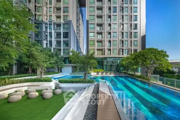 Luxurious modern apartment complex with stunning pool and lush greenery