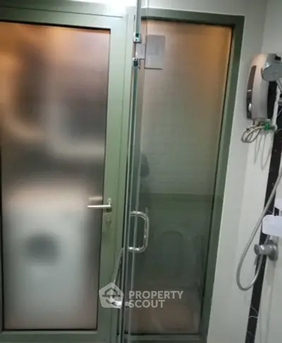 Modern bathroom with frosted glass shower door and sleek fixtures.