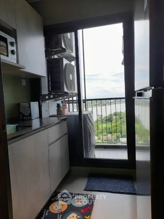 Modern kitchen with balcony view and sleek appliances in urban apartment