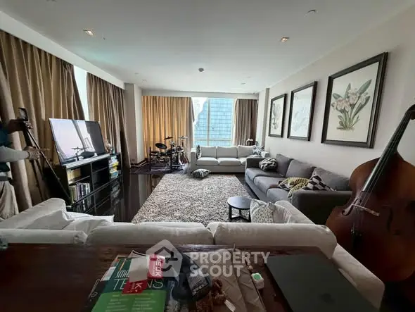 Spacious living room with large windows and city view, featuring modern furniture and musical instruments.