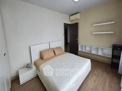 Spacious bedroom with modern decor and wooden flooring