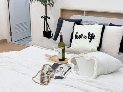 Cozy bedroom with stylish decor and wine setup, perfect for relaxation.